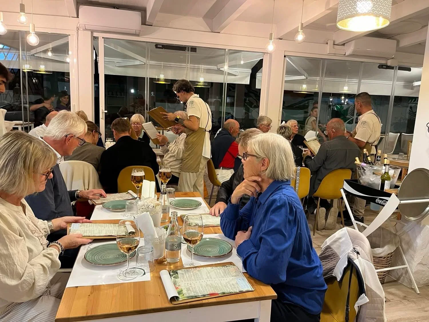 Gäster läser menyn på en restaurang i Cabanas medan personalen tar upp beställningar